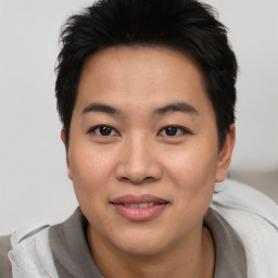 Joyful asian young-adult male with short  brown hair and brown eyes