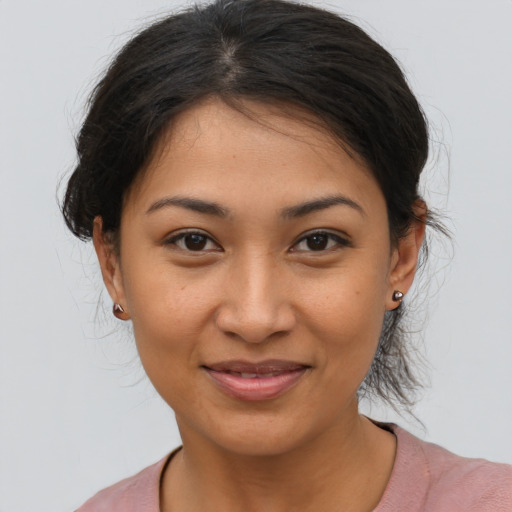 Joyful latino young-adult female with medium  brown hair and brown eyes