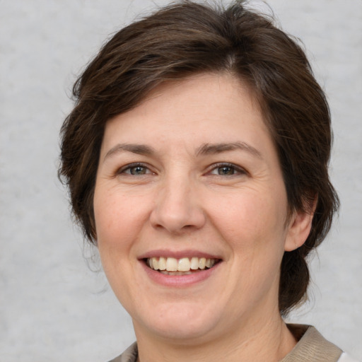 Joyful white adult female with medium  brown hair and brown eyes