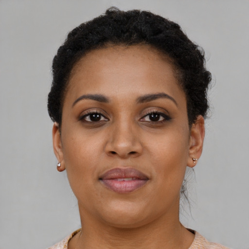 Joyful black young-adult female with short  brown hair and brown eyes