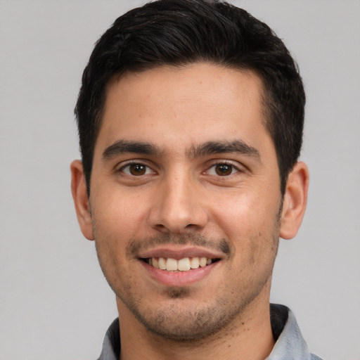 Joyful white young-adult male with short  black hair and brown eyes