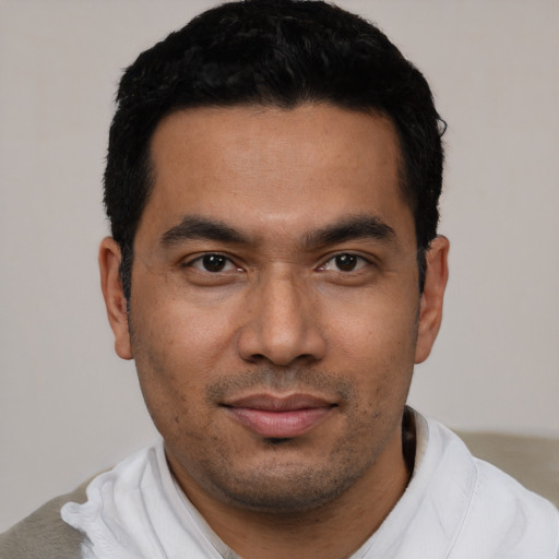 Joyful latino young-adult male with short  black hair and brown eyes