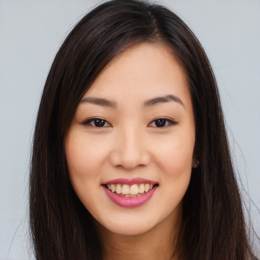 Joyful asian young-adult female with long  brown hair and brown eyes