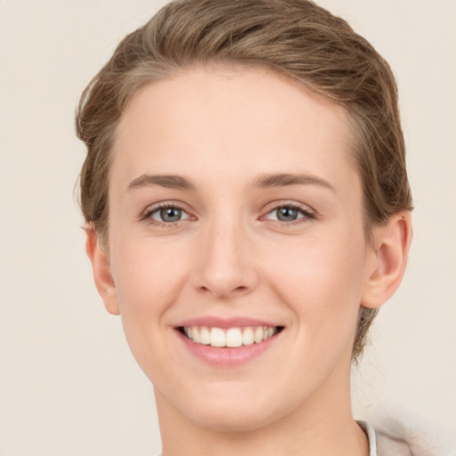 Joyful white young-adult female with short  brown hair and grey eyes