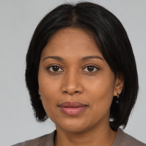 Joyful black young-adult female with medium  black hair and brown eyes