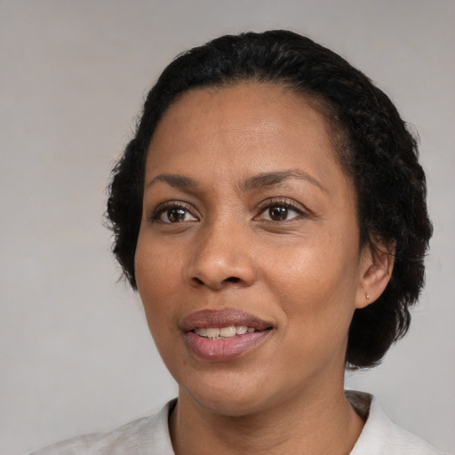 Joyful black adult female with short  black hair and brown eyes