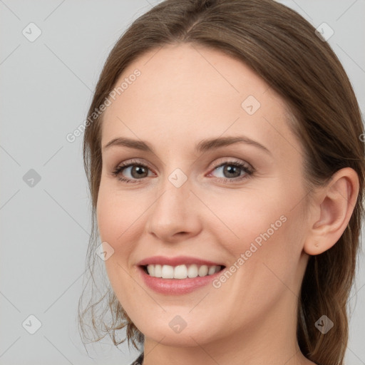 Joyful white young-adult female with long  brown hair and grey eyes