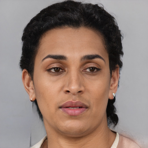 Joyful latino adult female with short  brown hair and brown eyes