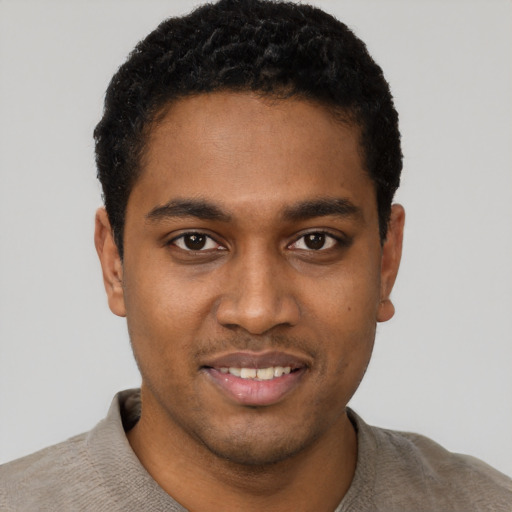 Joyful black young-adult male with short  black hair and brown eyes