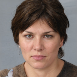 Joyful white adult female with medium  brown hair and grey eyes