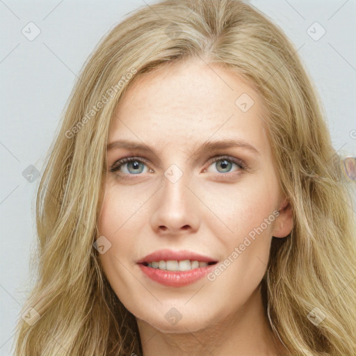 Joyful white young-adult female with long  brown hair and blue eyes