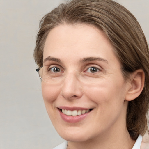 Joyful white adult female with medium  brown hair and grey eyes