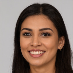 Joyful latino young-adult female with long  brown hair and brown eyes