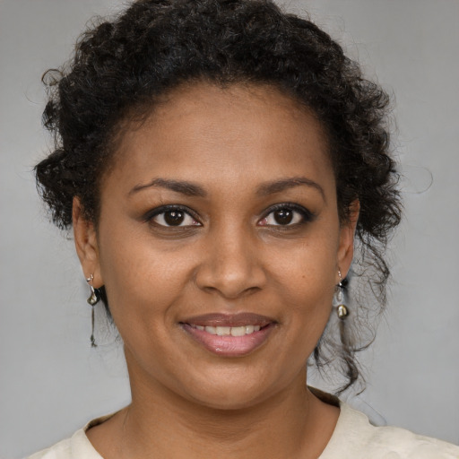 Joyful black young-adult female with short  brown hair and brown eyes