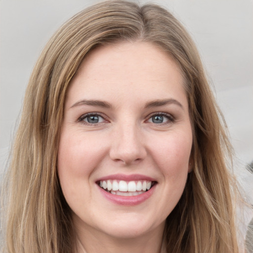 Joyful white young-adult female with long  brown hair and green eyes