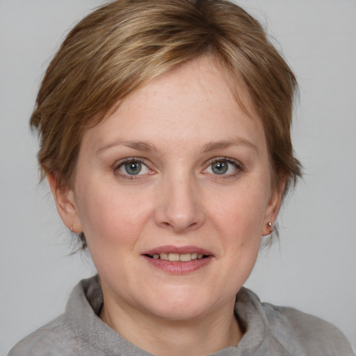 Joyful white adult female with medium  brown hair and blue eyes