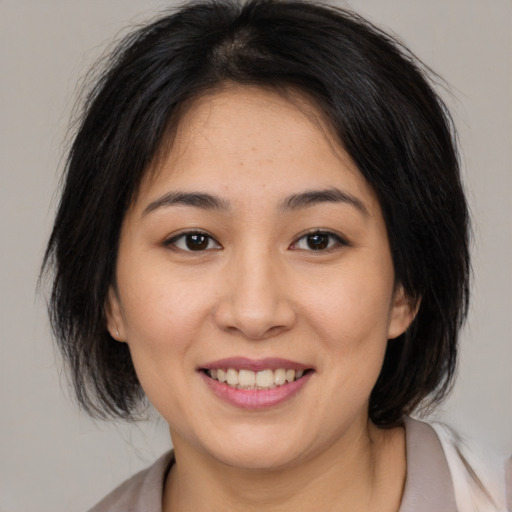 Joyful asian young-adult female with medium  brown hair and brown eyes