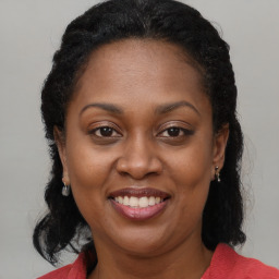 Joyful black adult female with medium  brown hair and brown eyes