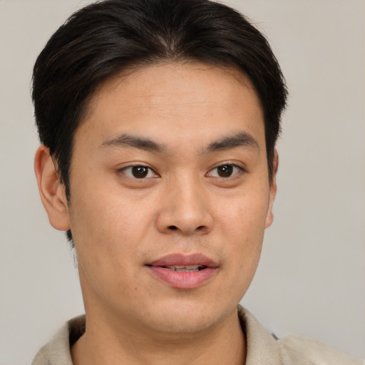 Joyful asian young-adult male with short  brown hair and brown eyes