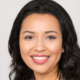 Joyful latino young-adult female with long  brown hair and brown eyes