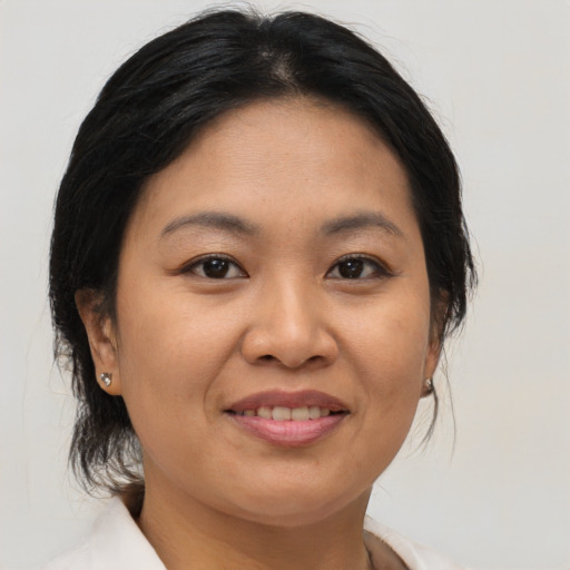 Joyful asian adult female with medium  brown hair and brown eyes