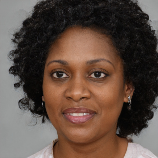 Joyful black adult female with medium  brown hair and brown eyes