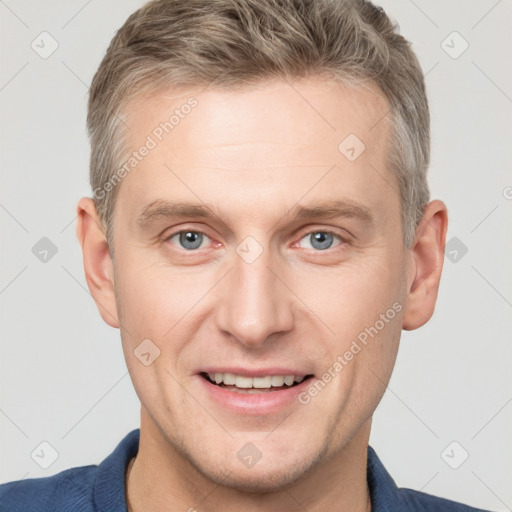 Joyful white adult male with short  brown hair and grey eyes