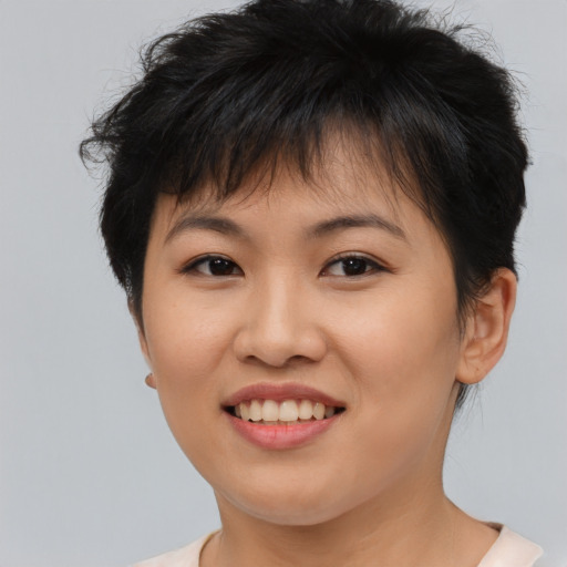 Joyful asian young-adult female with short  brown hair and brown eyes