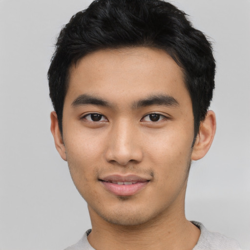 Joyful asian young-adult male with short  black hair and brown eyes