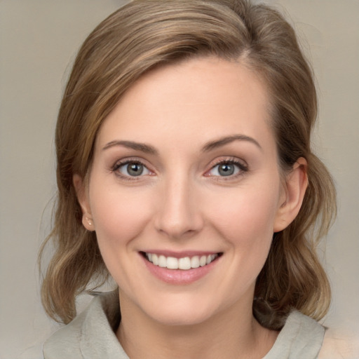 Joyful white young-adult female with medium  brown hair and green eyes