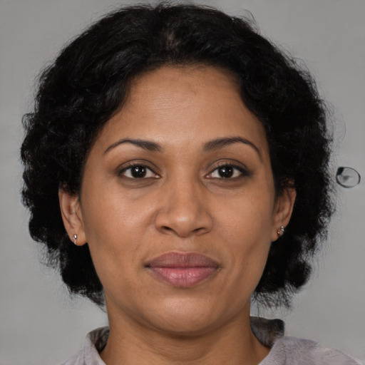 Joyful latino adult female with medium  brown hair and brown eyes