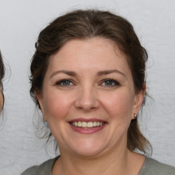 Joyful white adult female with medium  brown hair and blue eyes