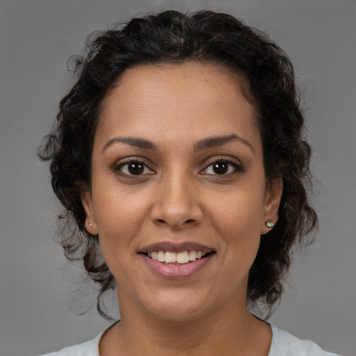 Joyful latino adult female with medium  brown hair and brown eyes