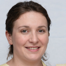 Joyful white adult female with medium  brown hair and grey eyes