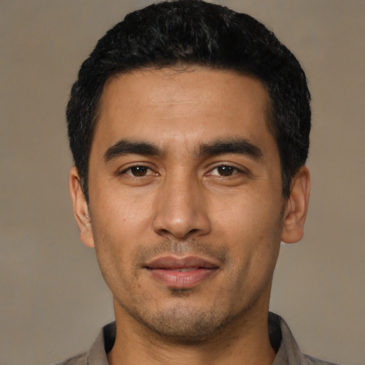 Joyful latino young-adult male with short  black hair and brown eyes