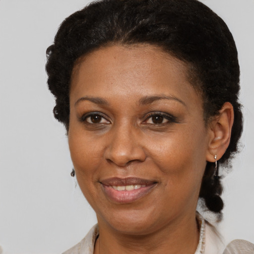 Joyful black adult female with short  brown hair and brown eyes