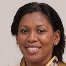 Joyful black adult female with medium  brown hair and brown eyes