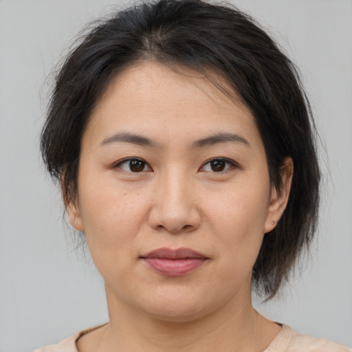 Joyful asian young-adult female with medium  brown hair and brown eyes