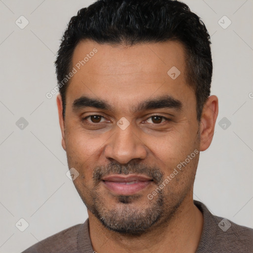 Joyful latino young-adult male with short  black hair and brown eyes