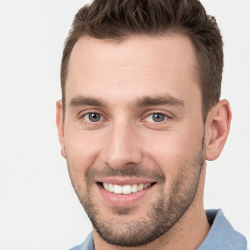 Joyful white young-adult male with short  brown hair and grey eyes