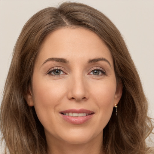 Joyful white young-adult female with long  brown hair and green eyes