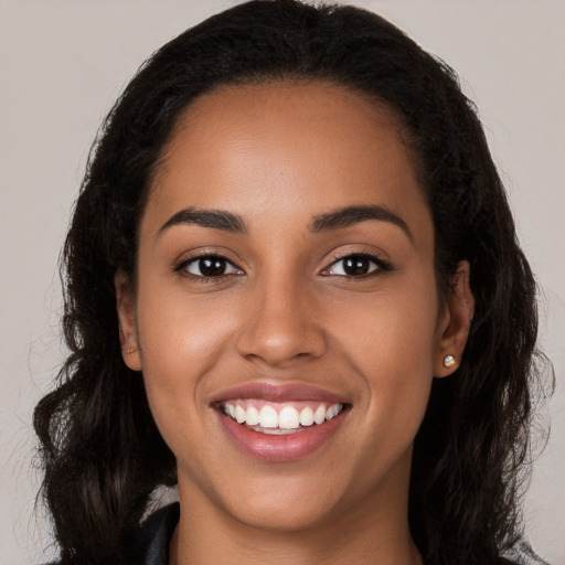 Joyful latino young-adult female with long  brown hair and brown eyes