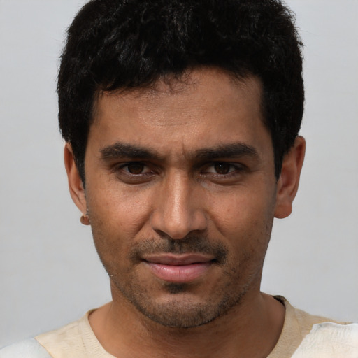 Joyful white young-adult male with short  black hair and brown eyes