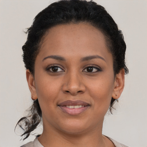 Joyful black young-adult female with short  brown hair and brown eyes