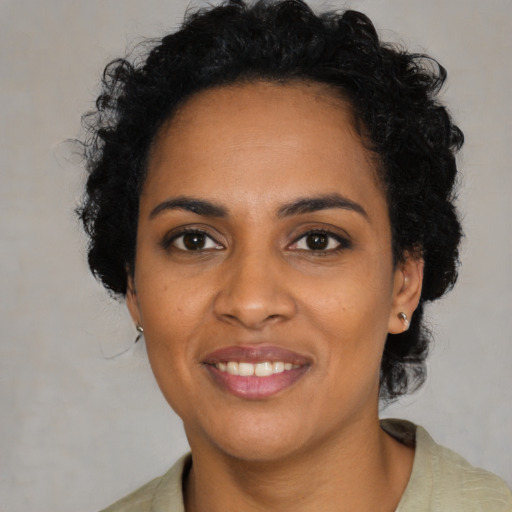 Joyful black young-adult female with medium  black hair and brown eyes