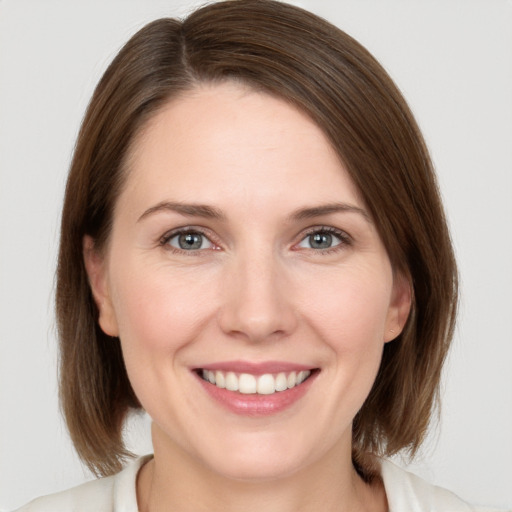 Joyful white young-adult female with medium  brown hair and grey eyes