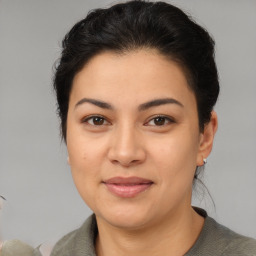 Joyful latino young-adult female with medium  brown hair and brown eyes