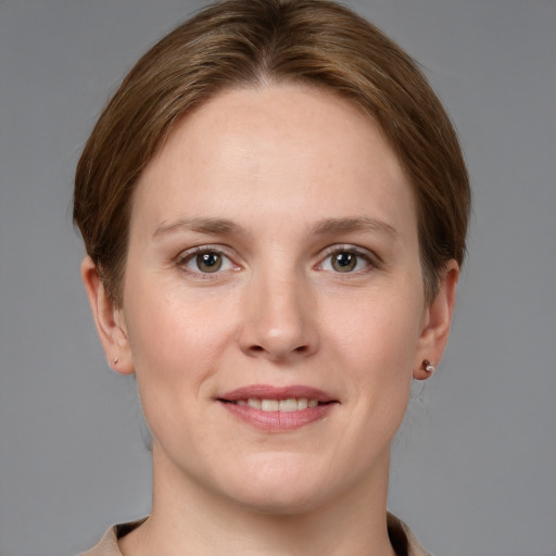 Joyful white young-adult female with short  brown hair and grey eyes