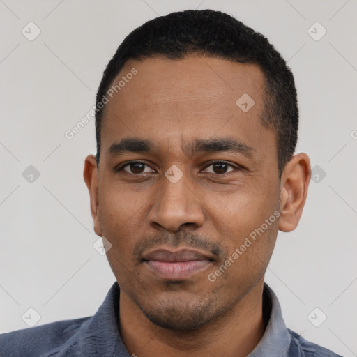 Joyful black young-adult male with short  black hair and brown eyes