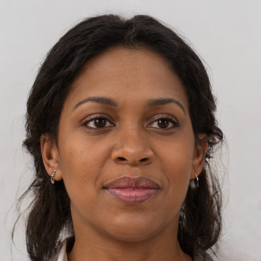Joyful black adult female with long  brown hair and brown eyes
